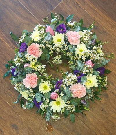 Pastel classic Wreath - Classic Wreath with pastel flowers.This classic wreath an elegant mix of pastel seasonal  flowers designed by our expert florists. A perfect tribute to say your final farewell to a loved one, friend or colleague. If you have a specific request to be included in this wreath please place a note on your order or alternatively you speak directly to one of our florists on 0191 2522553 are opening hours are Monday to Friday 9.00 to 5.30 or email us at thegardenshopflorist@hotmail.com We will do our best to accomadate your requests.